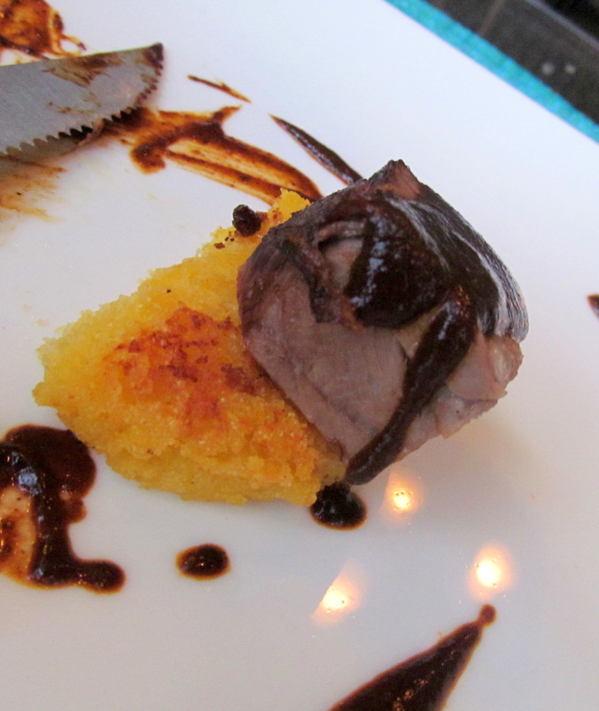 Braised short rib atop a pepperjack and cheddar arepe (cornmeal cake), paired with a mole negro sauce.